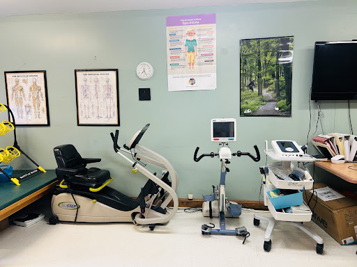 A well-equipped physical therapy room featuring various exercise machines and monitoring tools.