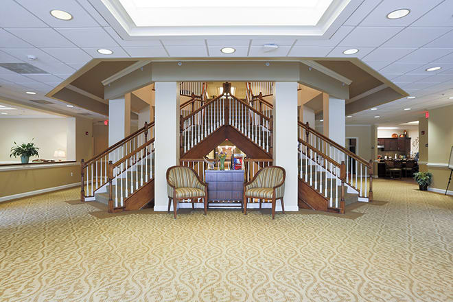A spacious lobby area featuring a grand staircase and comfortable seating.
