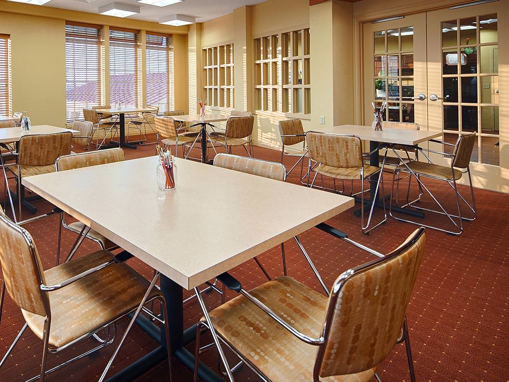 An empty dining area with modern tables and chairs arranged neatly.