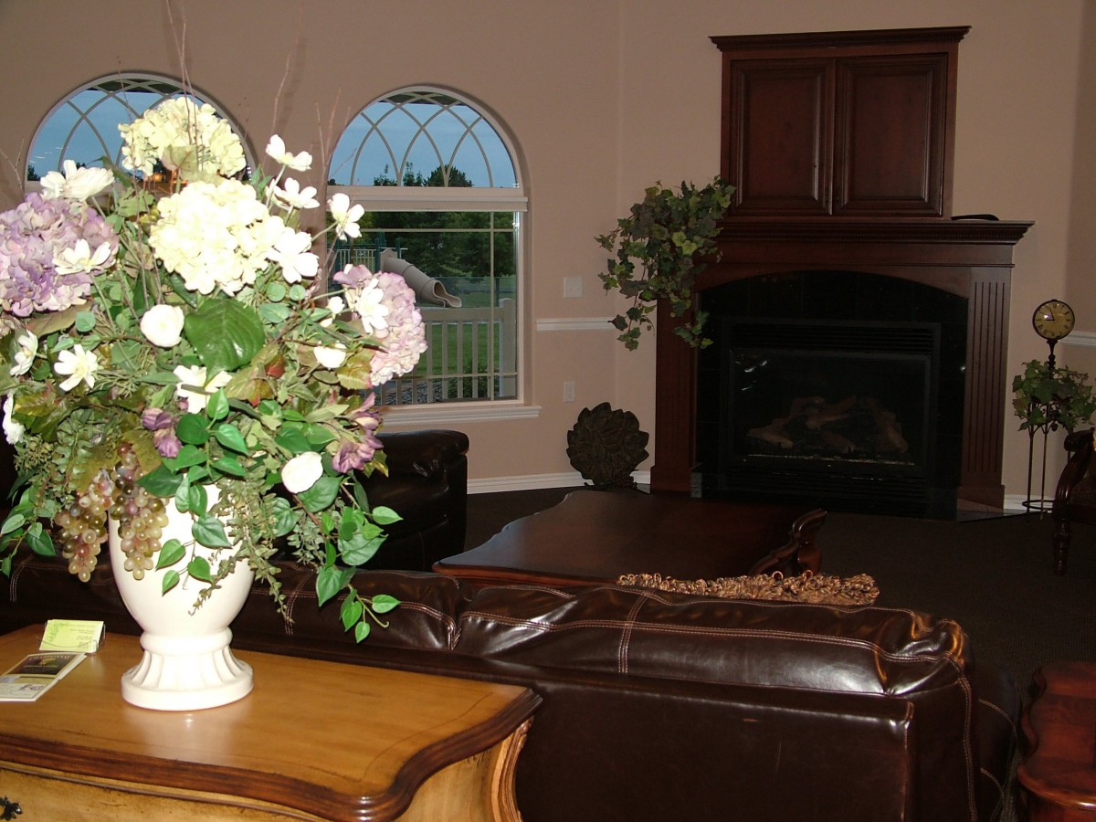 A cozy living room with a floral arrangement and a fireplace.