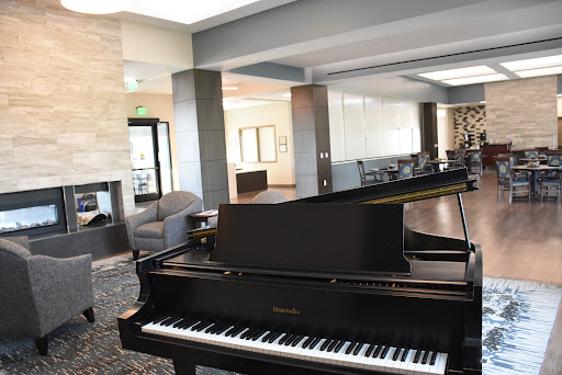 A sleek grand piano in a modern lounge area, inviting guests to enjoy music in a stylish setting.