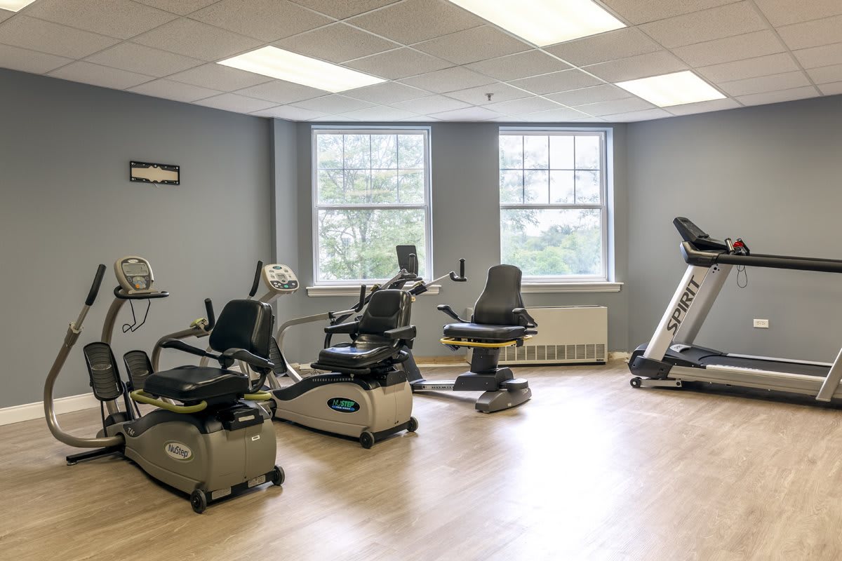 A rehabilitation room with various exercise equipment for physical therapy.