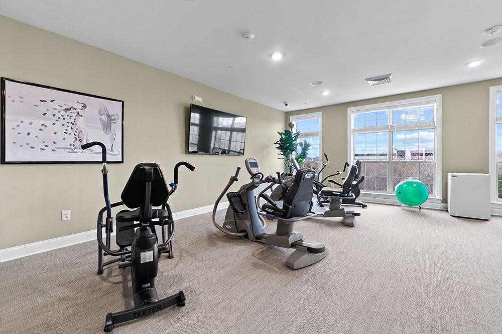 A well-equipped gym with stationary bikes, treadmills, and a wall-mounted television.