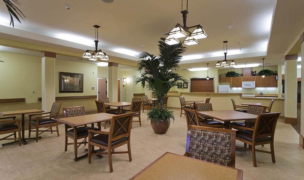 A modern dining area featuring wooden tables, chairs, and decorative lighting.