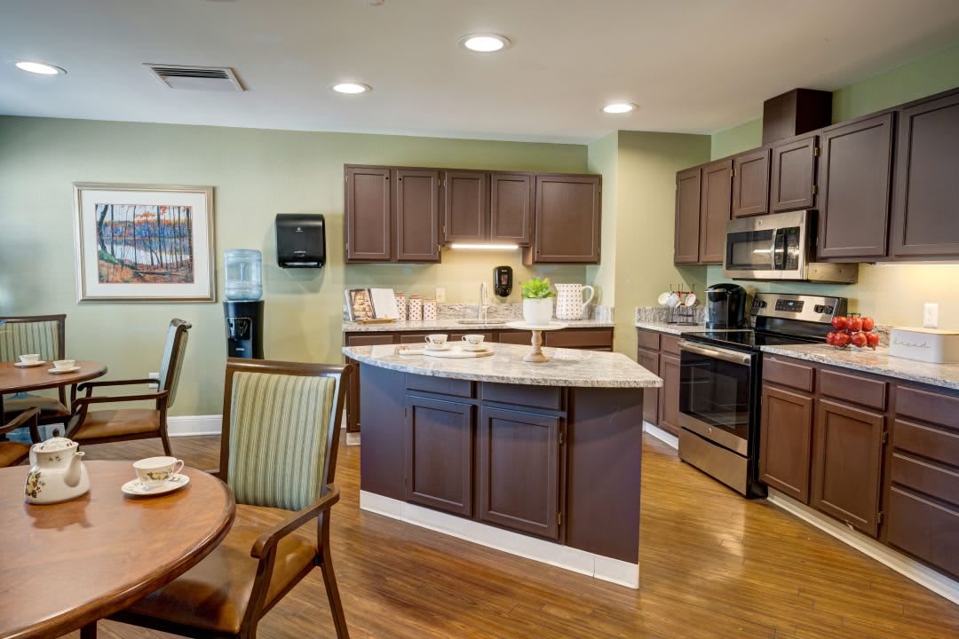A modern kitchen interior with wooden cabinets, an island counter, and a dining area.