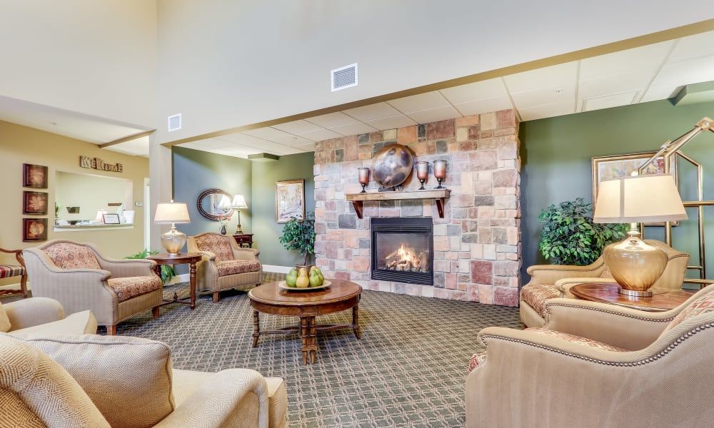A cozy living room with a central fireplace, surrounded by comfortable seating and elegant decor.