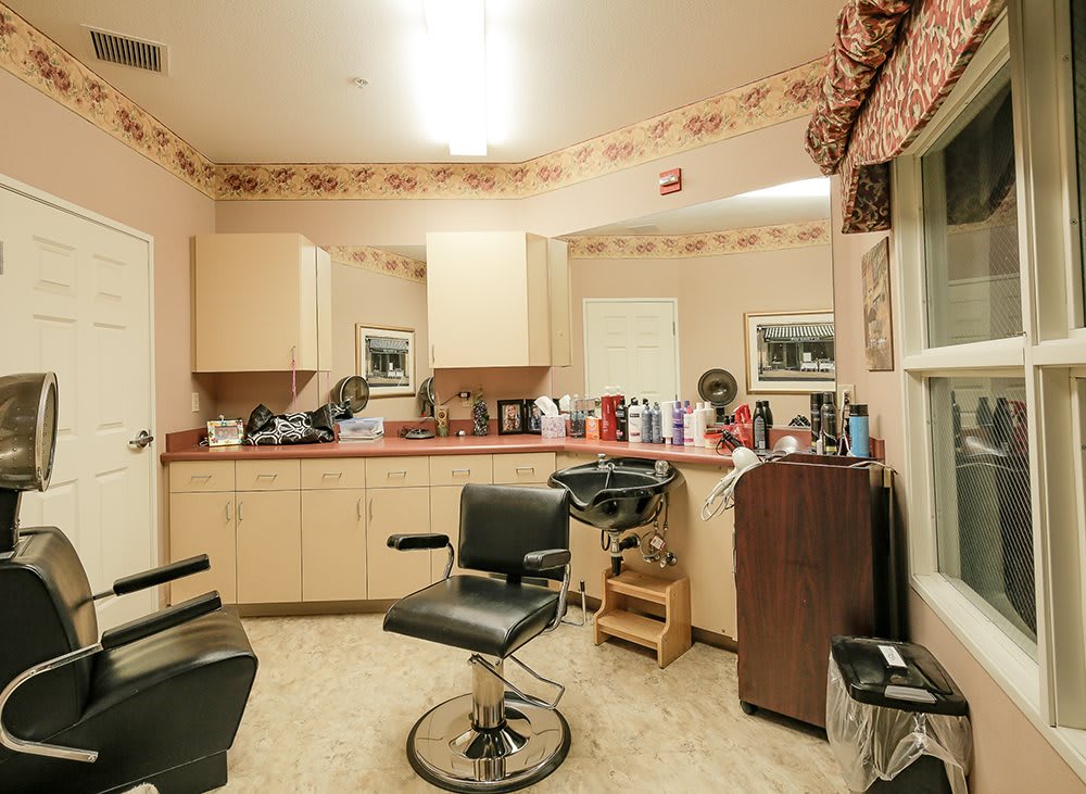 A cozy hair salon with a styling chair and various beauty products on the counter.