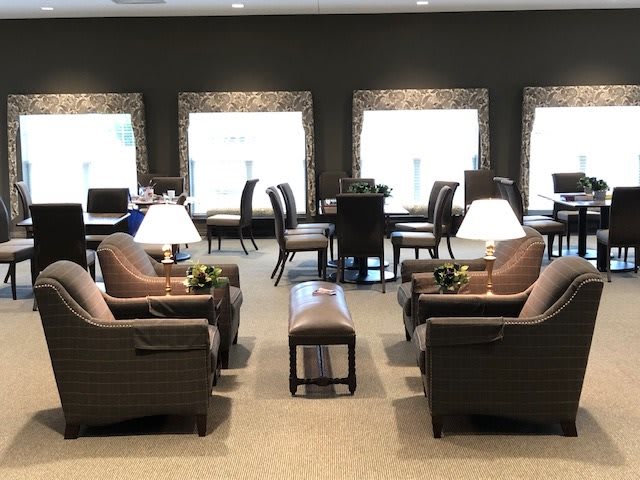 A cozy lounge area with comfortable seating and natural light from large windows.