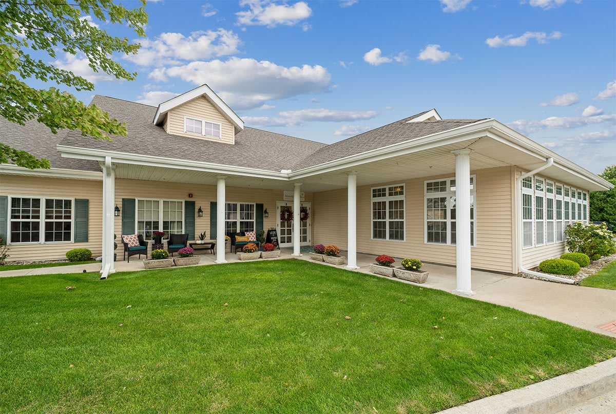 A spacious residential home with a covered porch and well-maintained lawn.