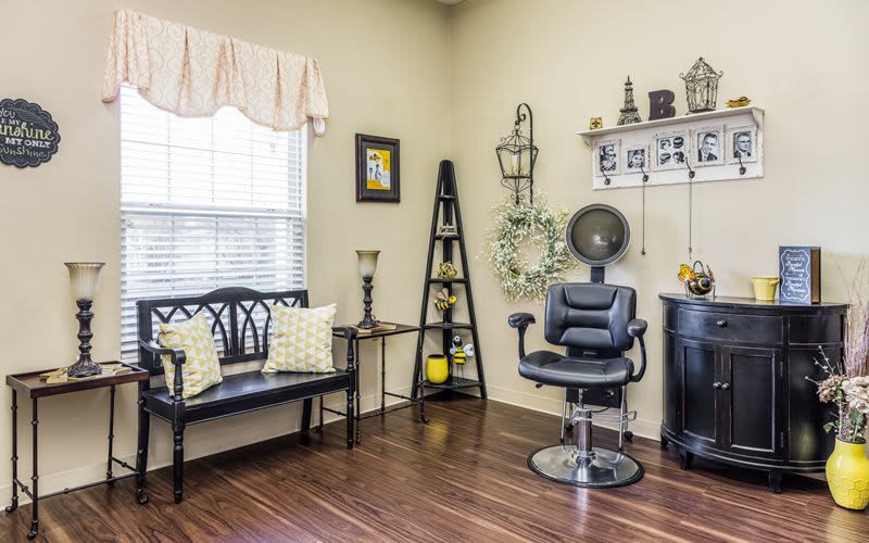 A cozy salon interior featuring a barber chair and waiting area with elegant decor.
