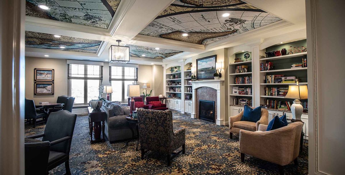A cozy living room with elegant interior decor, featuring a fireplace and bookshelves.