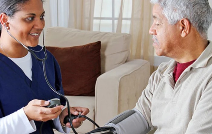 A nurse measuring the blood pressure of an elderly patient at home.