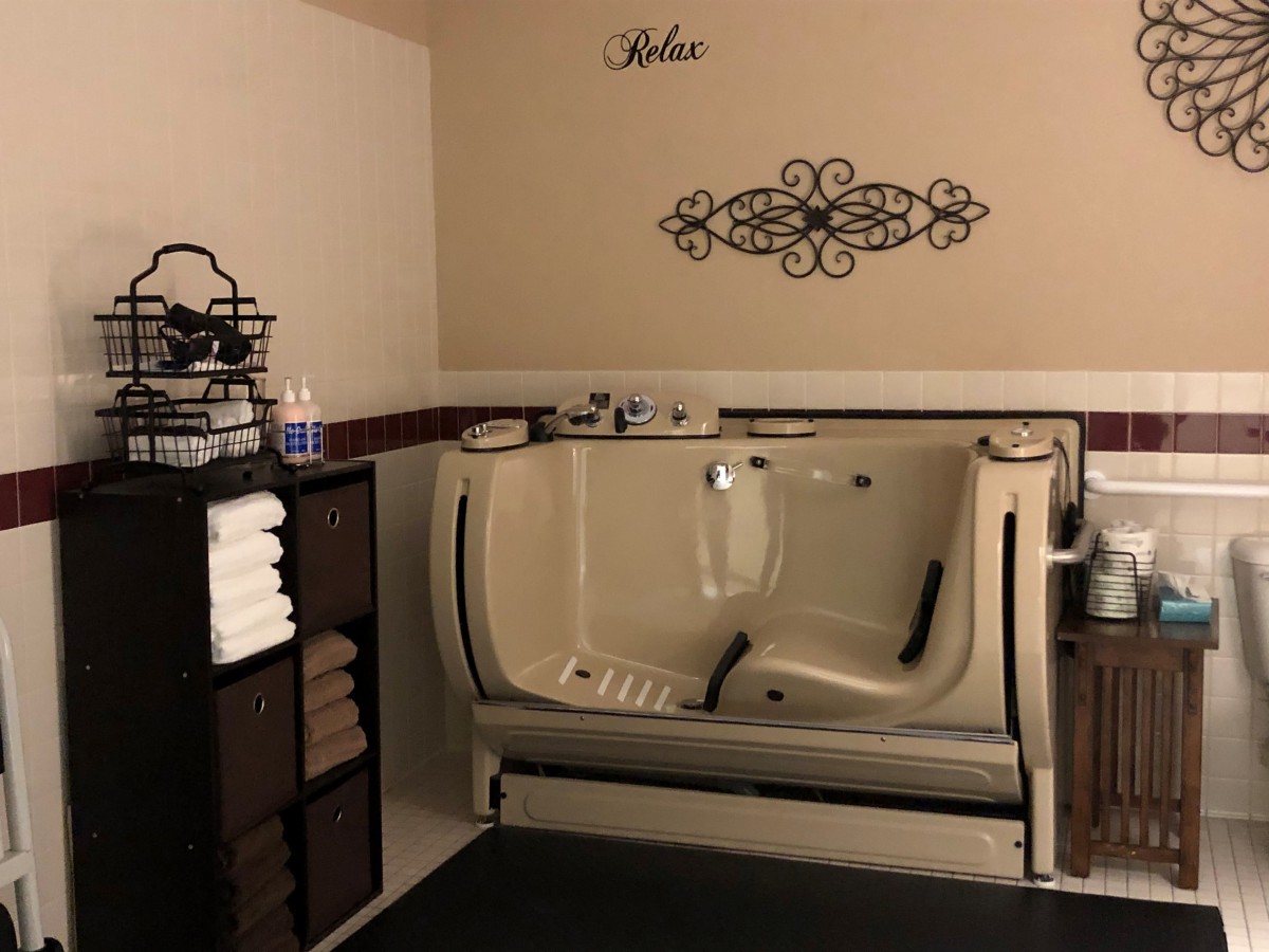 A well-appointed bathroom featuring a comfortable bathtub and neatly organized towels.