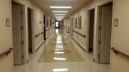 A well-lit corridor with multiple doors lining the walls, showcasing a clean and organized environment.