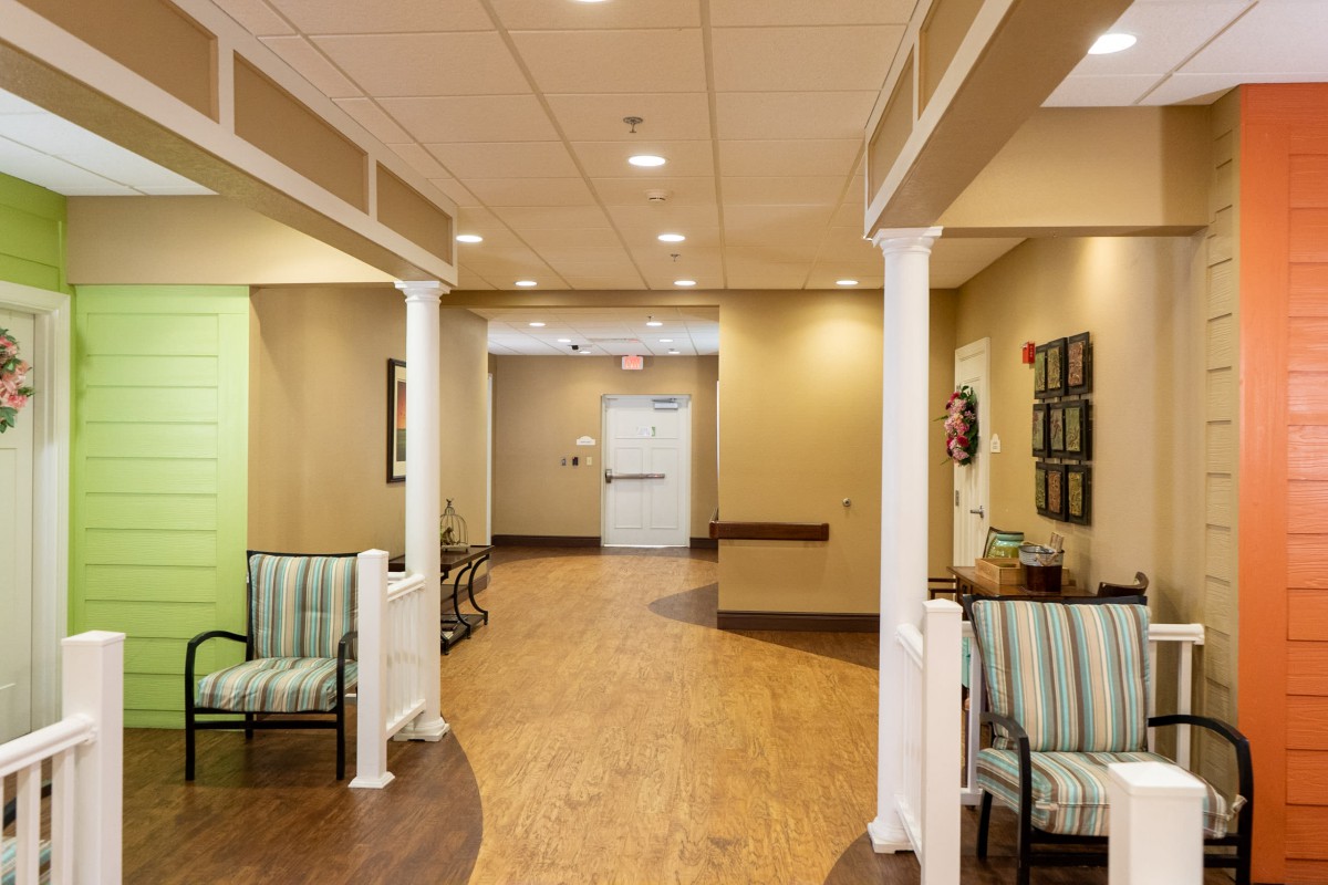 A warmly lit hallway with seating and decorative columns.