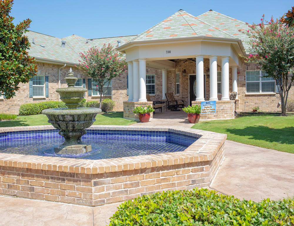 A beautifully landscaped garden with a central fountain and gazebo.