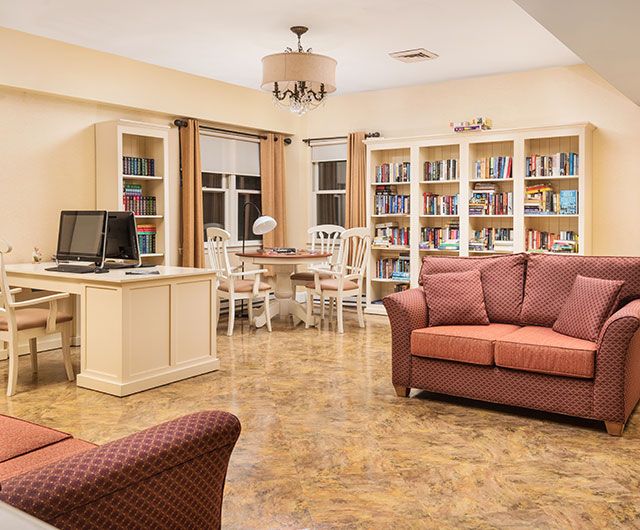 A cozy living room with bookshelves and a home office area.