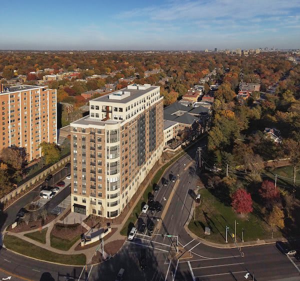 Aerial view of a city intersection surrounded by autumn trees and high-rise buildings.