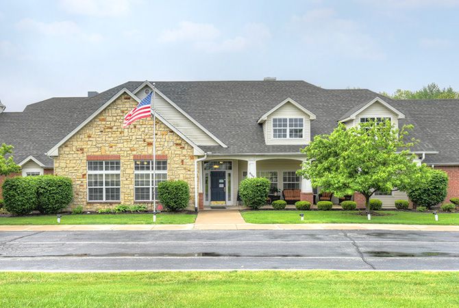 A suburban house with a well-maintained lawn and an American flag displayed outside.