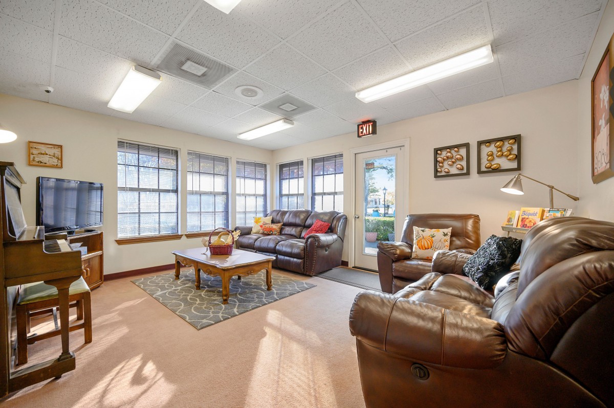 A cozy living room with comfortable seating, large windows, and decorative accents.