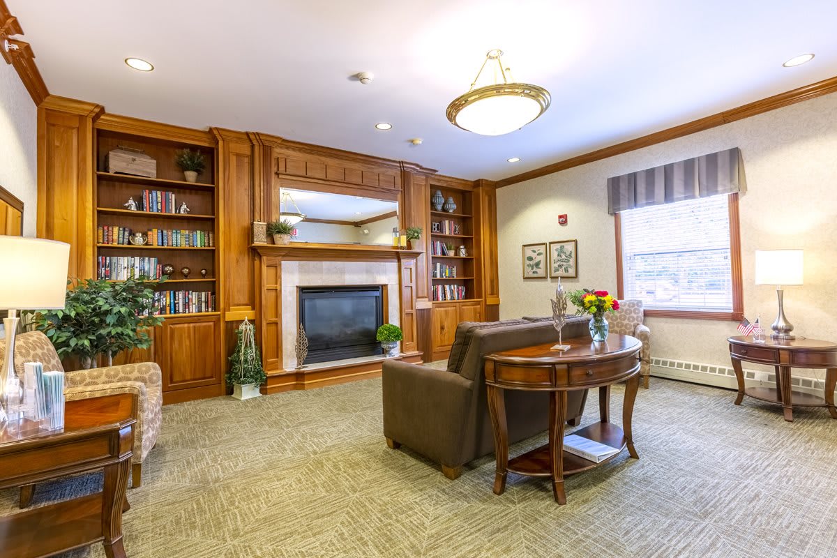 A cozy living room featuring a fireplace, wooden shelves, and comfortable seating.