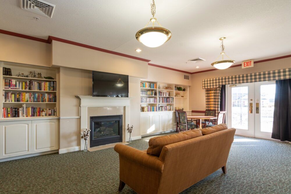 A cozy living room with a fireplace, television, and bookshelf.