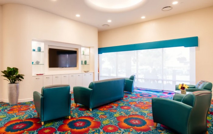 A modern lounge area with colorful carpet and comfortable seating.