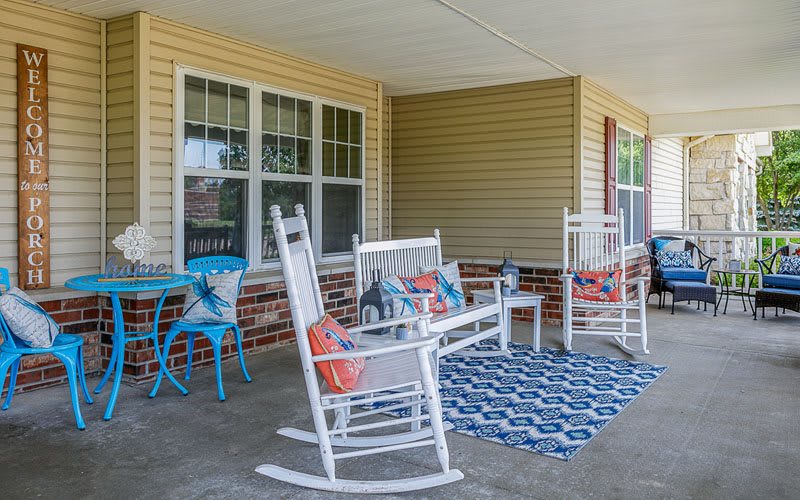 A cozy porch with rocking chairs and colorful decor.