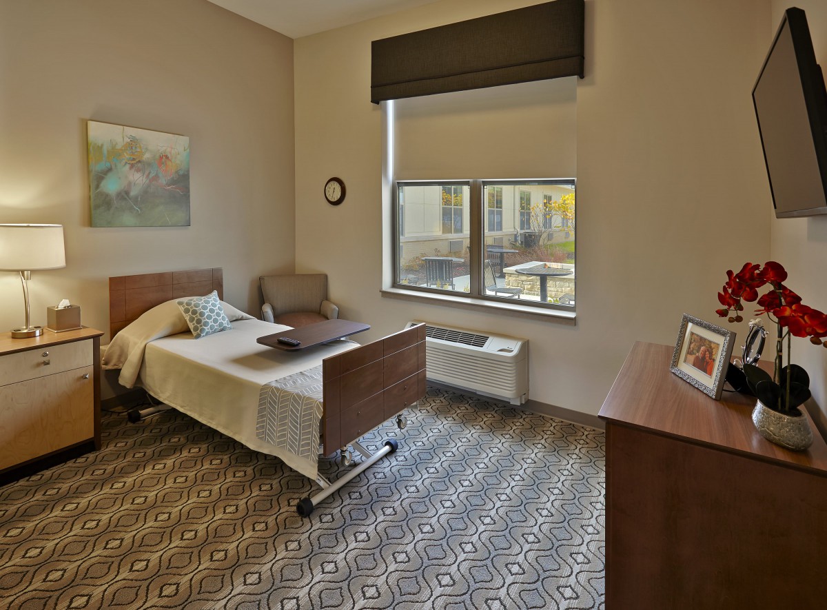 A cozy and well-lit bedroom with a single bed and modern furnishings.