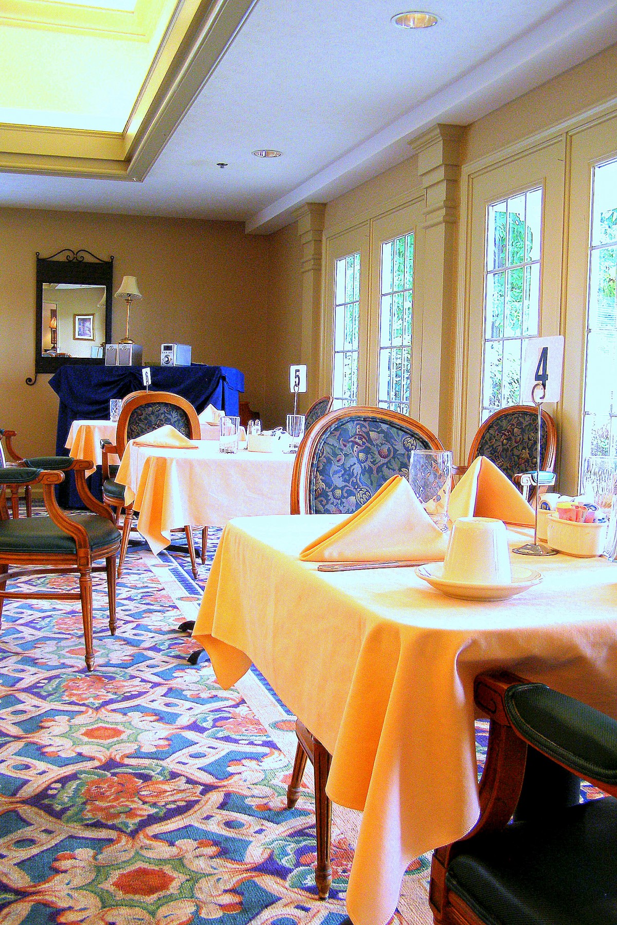 A cozy restaurant dining area with neatly set tables and large windows.