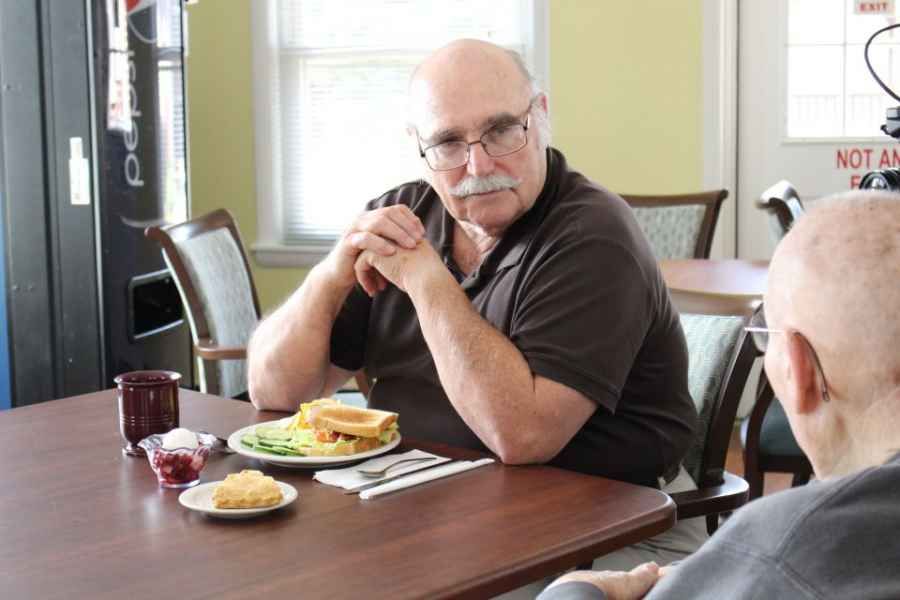 A man sitting at a table with a meal in front of him.