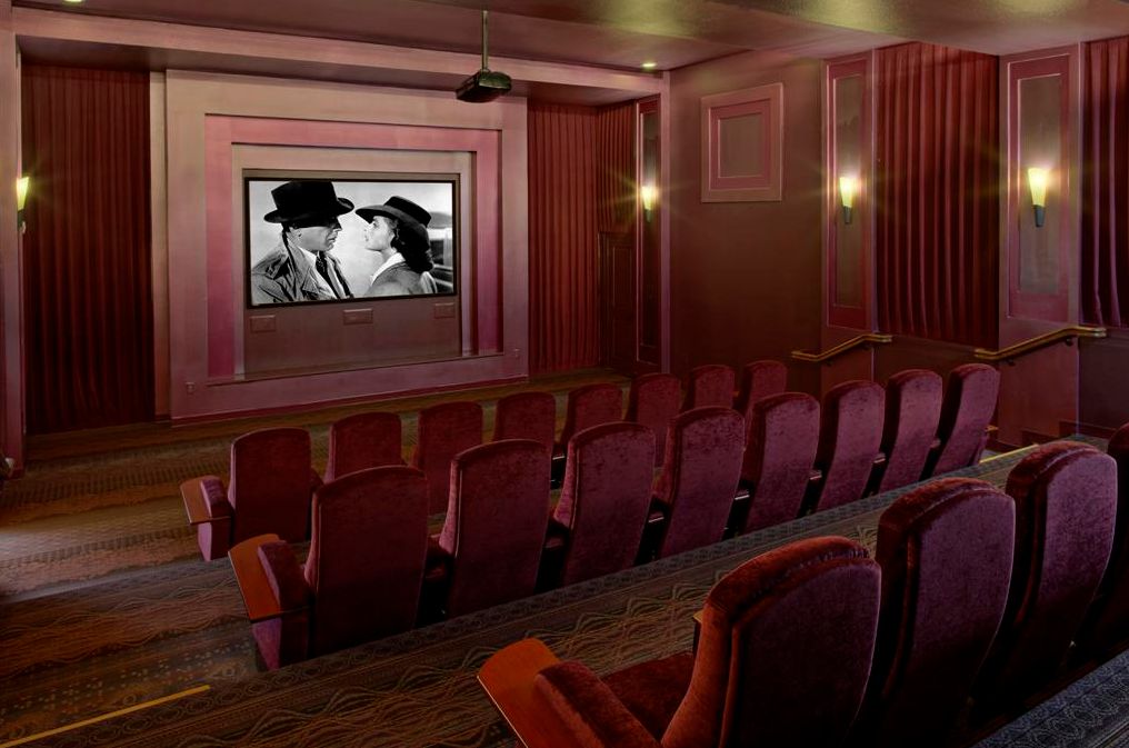 An empty movie theater showing a classic film in black and white.