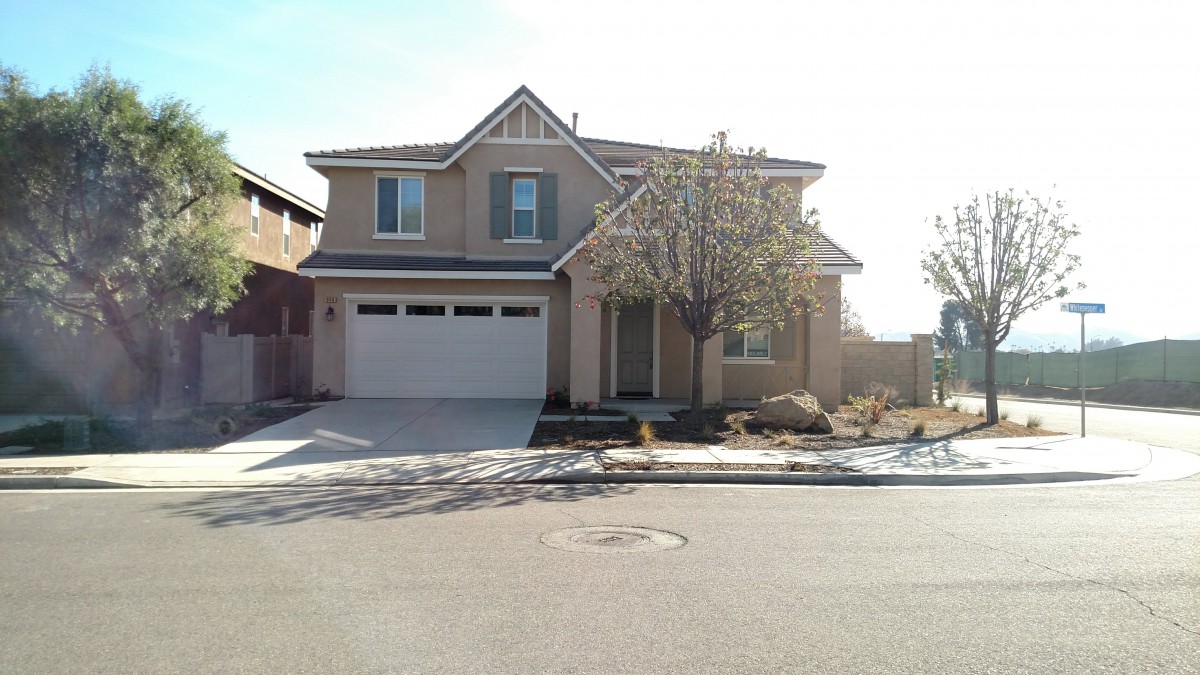 A two-story suburban house with a garage and driveway.