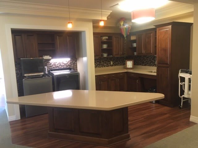 A spacious kitchen with wooden cabinets, a central island, and modern appliances.