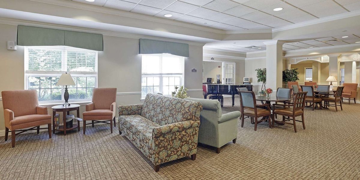 A cozy lounge area with sofas and armchairs arranged around a carpeted floor.
