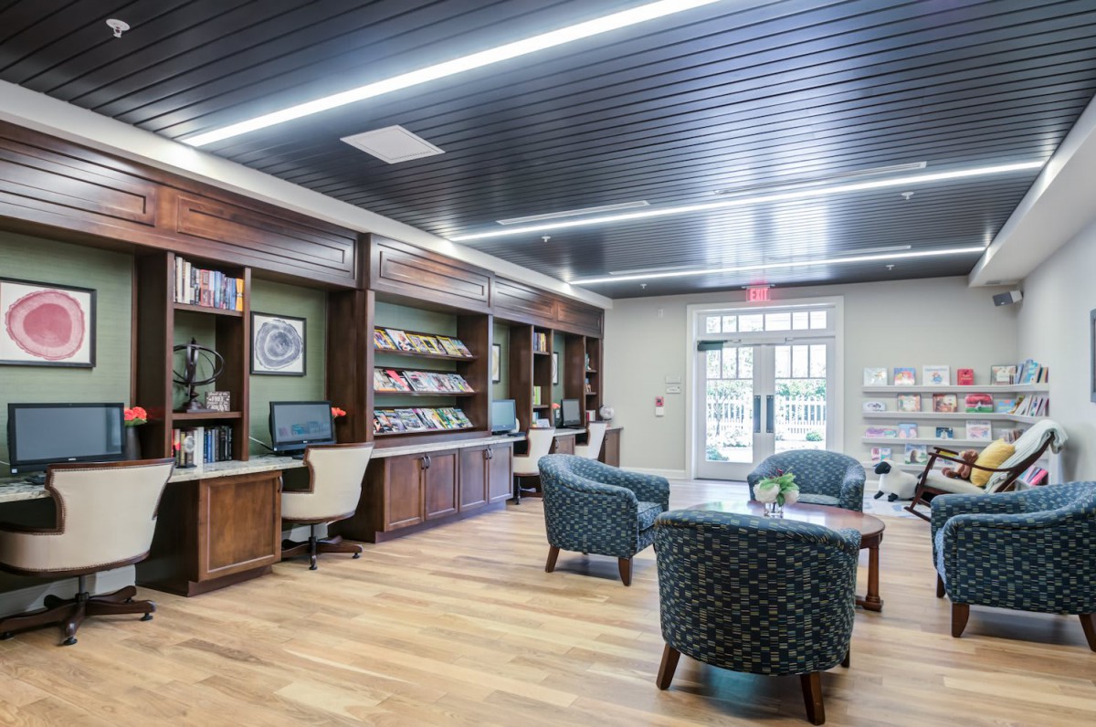 A modern lobby with comfortable seating and bookshelves.