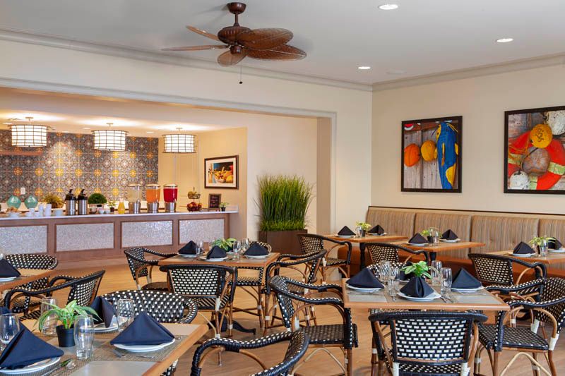 A cozy dining area with neatly arranged tables and chairs, adorned with elegant dcor and artwork.