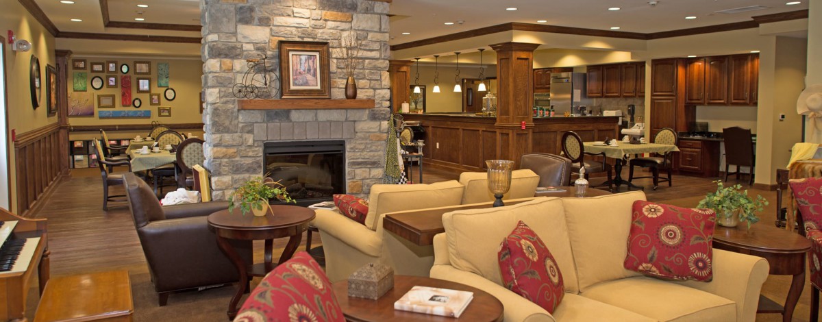 A cozy living room with a stone fireplace and comfortable seating.
