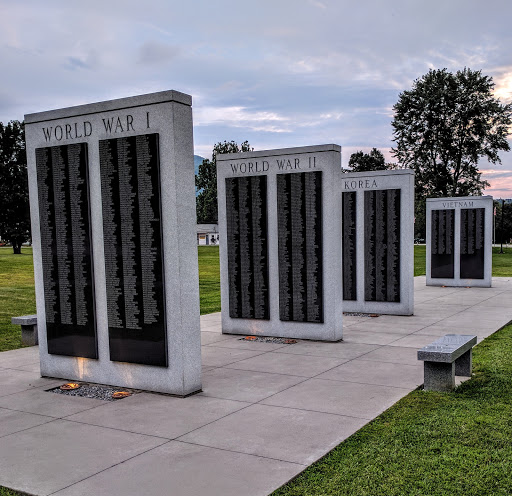 A memorial featuring several stone slabs displaying names, dedicated to honoring individuals from a significant historical event.