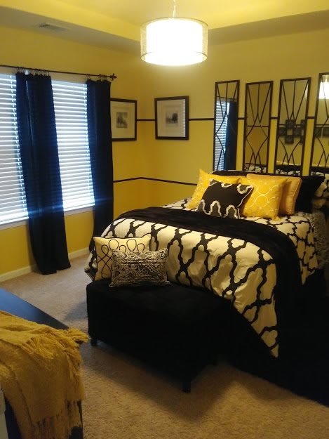 A stylish bedroom featuring yellow walls, black and white bedding, and coordinated decor.