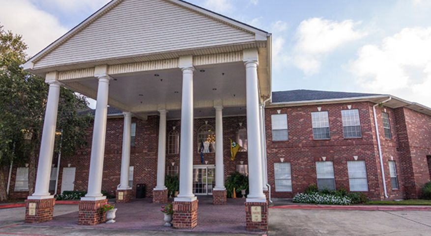 A classic building entrance with large white columns and a brick exterior.