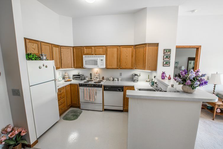 A modern kitchen interior with wooden cabinets, appliances, and a clean countertop.