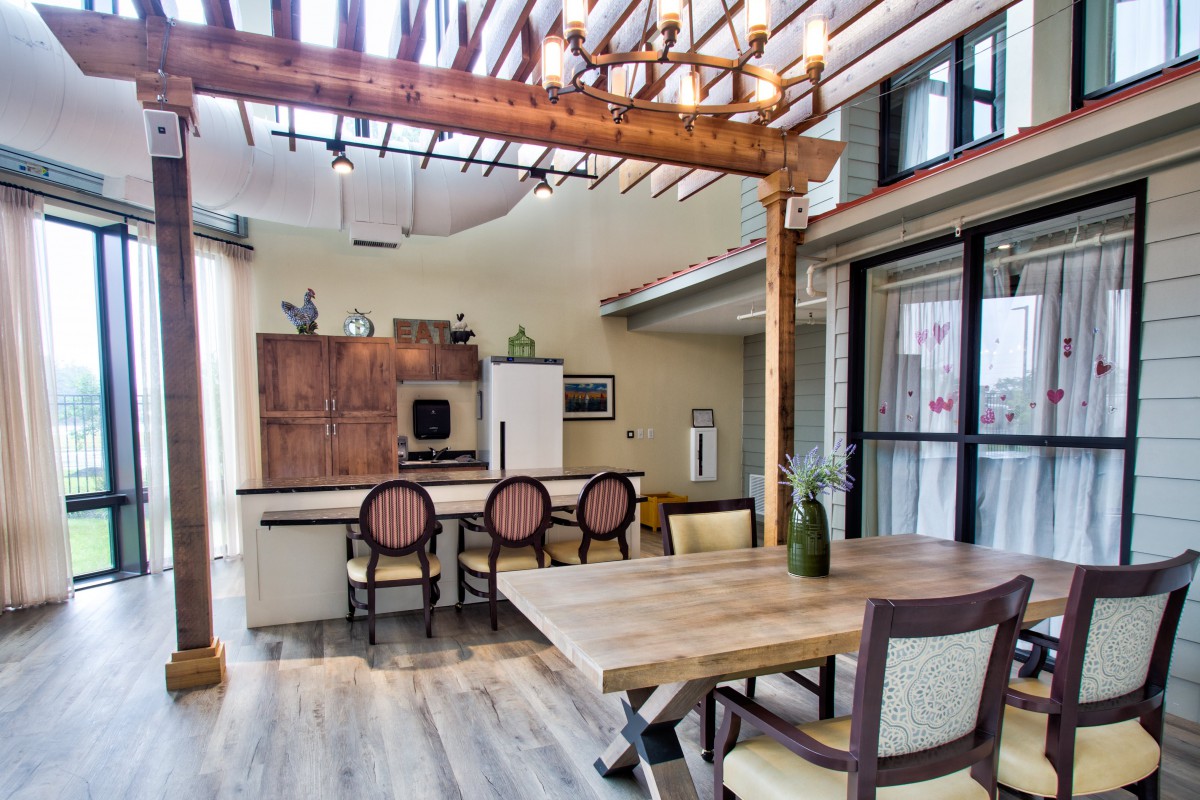 A modern kitchen and dining area with wooden furnishings and ample natural light.