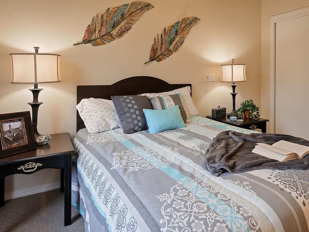 A cozy bedroom with stylish bedding and decorative wall art.