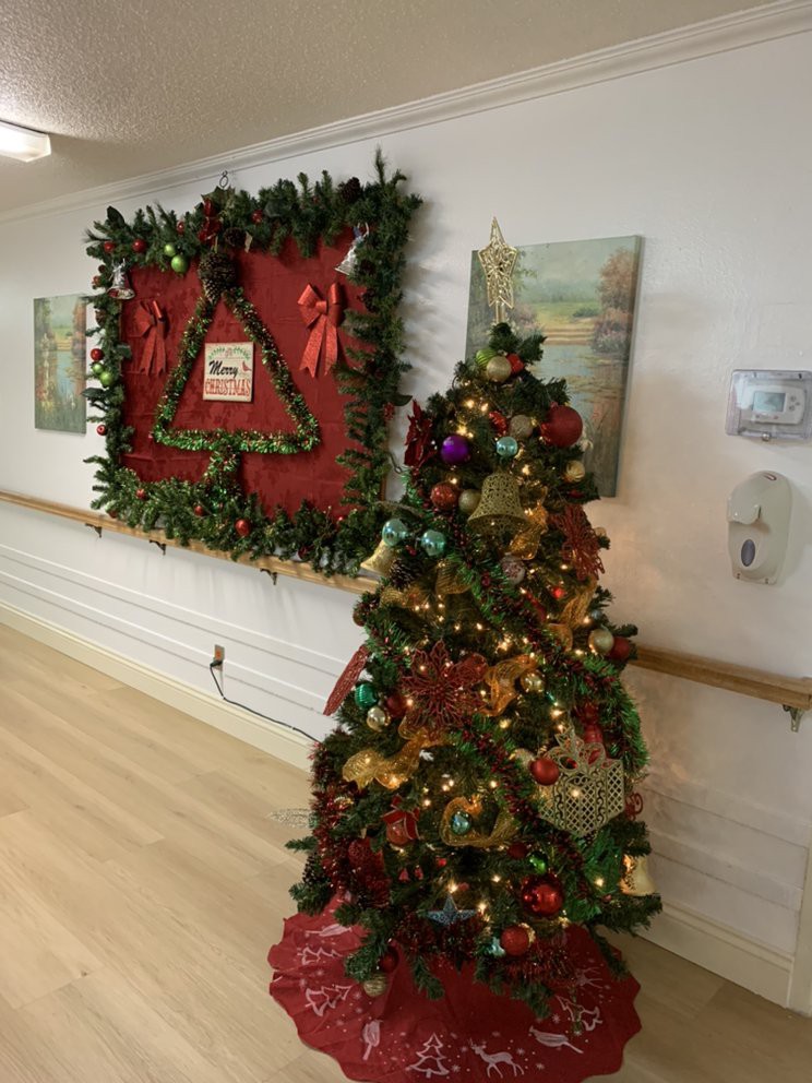 A hallway decorated with a Christmas tree and festive garlands.