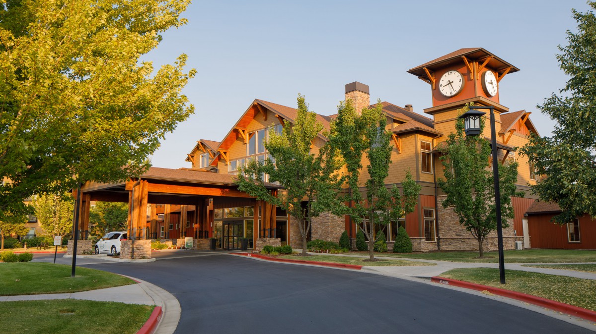 A modern building with a clock tower surrounded by trees.