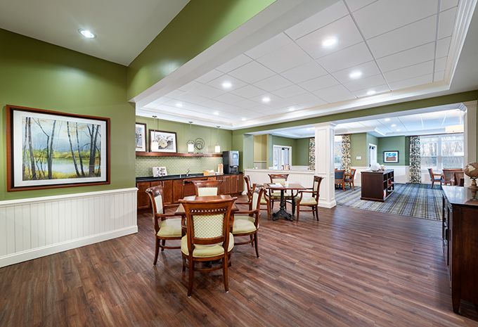A modern dining area with elegant tables and chairs, featuring wood flooring and soft ceiling lighting.