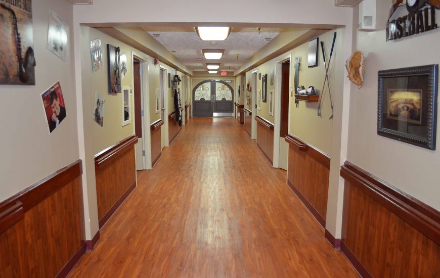 A clean and well-lit hallway with wooden flooring and decorated walls.