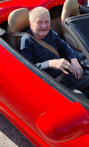 A person enjoying a drive in a red car.