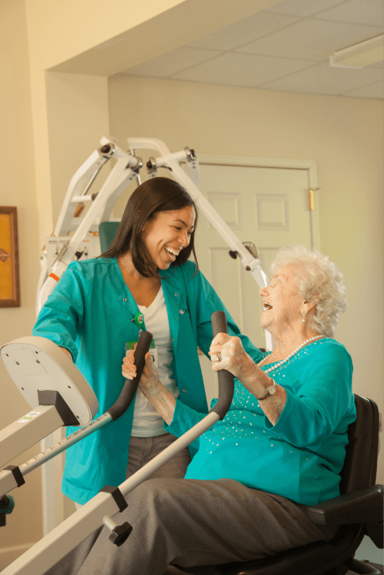 A healthcare professional assists an elderly patient during a rehabilitation session.